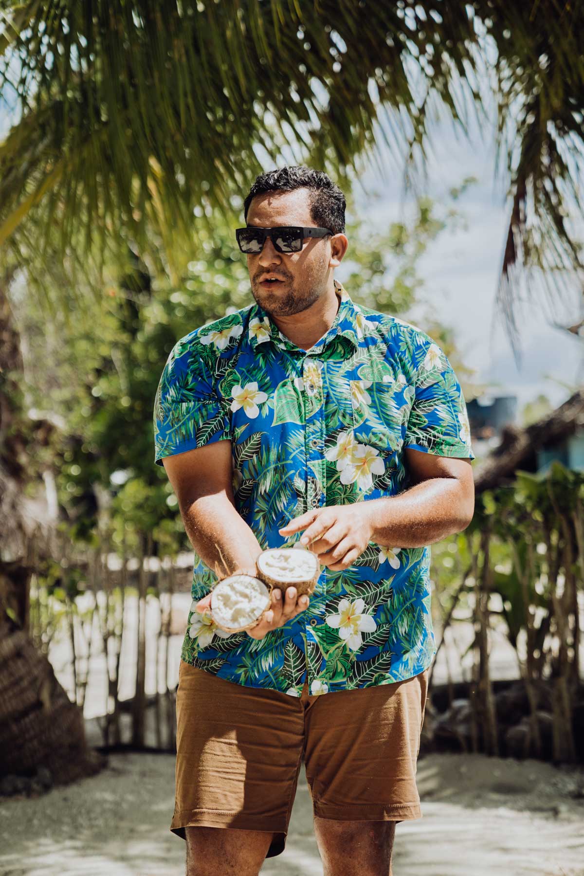 a local guide showing how to open a coconut in Bora Bora