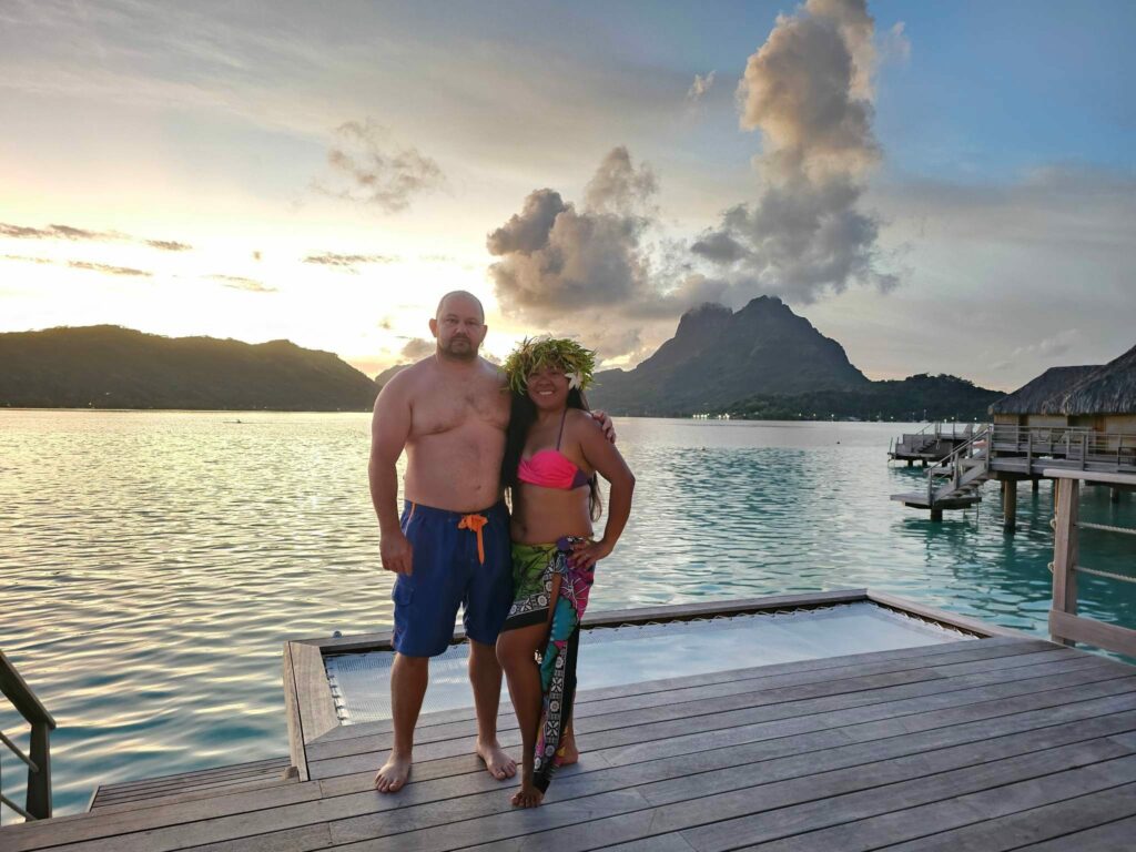 Couple posing on an overwater bungalow with Otemanu view at Le Bora Bora