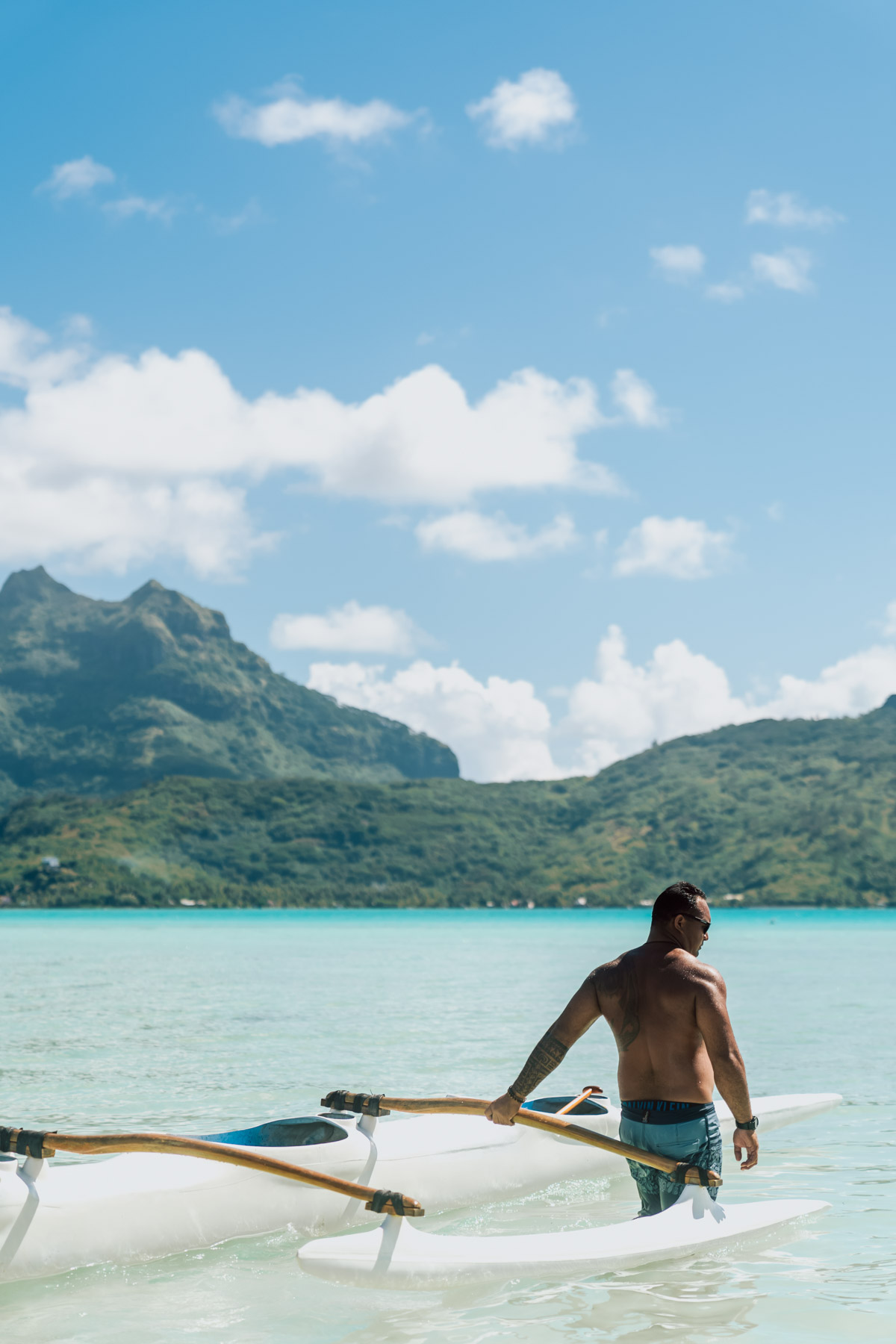 Polynesian man with a va'a trigger canoe in bora bora