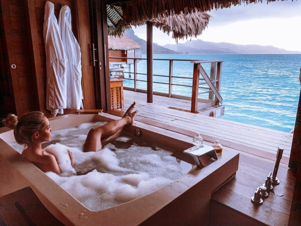Girl taking a bath looking at the lagoon at the Four Seasons Bora Bora