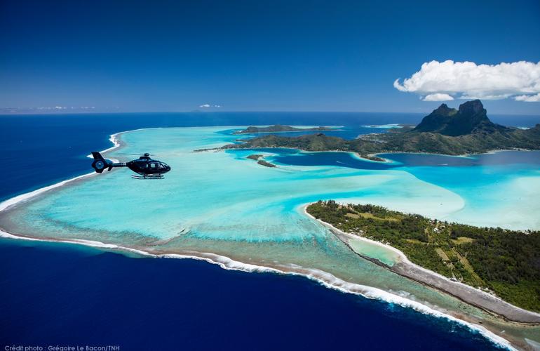 Bora Bora island aerial view with an helicopter