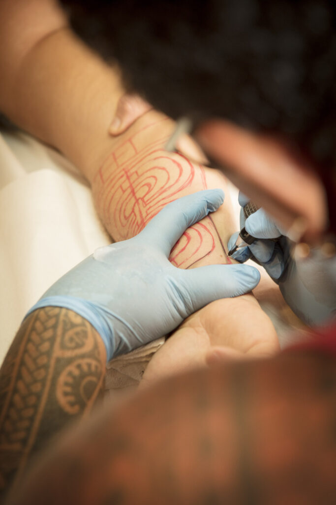 Someone getting a polynesian tattoo
