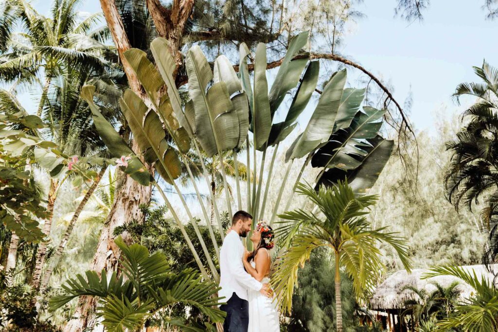 A couple facing each other in tropical gardens
