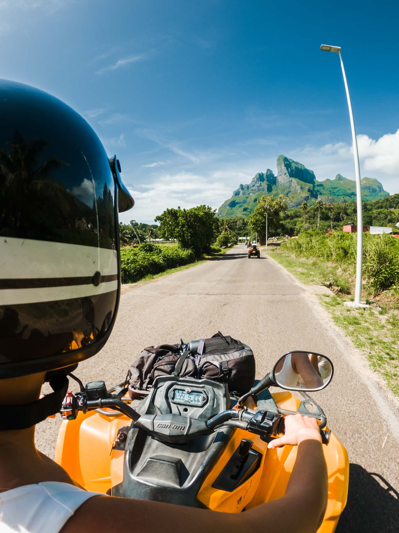 A woman driving an ATV in Bora Bora with mountain view