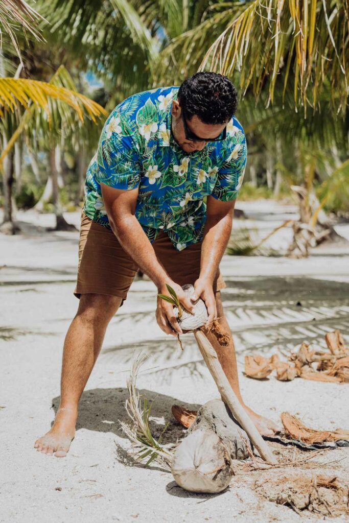 a local guide showing how to open a coconut in Bora Bora