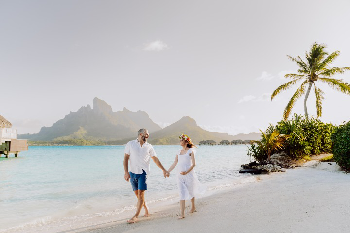 couple having a babymoon photoshoot on the beach in Bora Bora