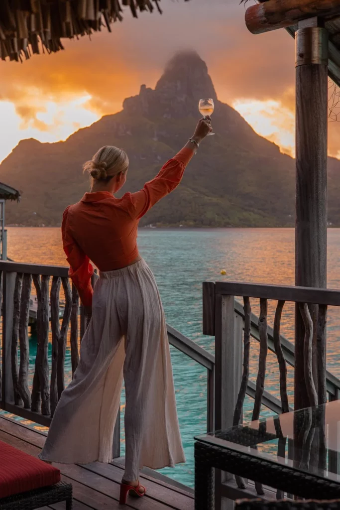 girl on an overwater bungalow at sunset in bora bora