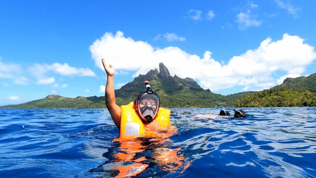 A woman snorkeling in Bora Bora with a full face mask