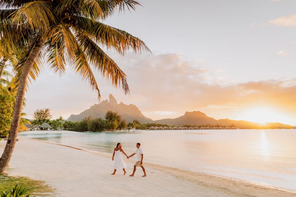 A couple having a walk at sunset on a Bora Bora Beach